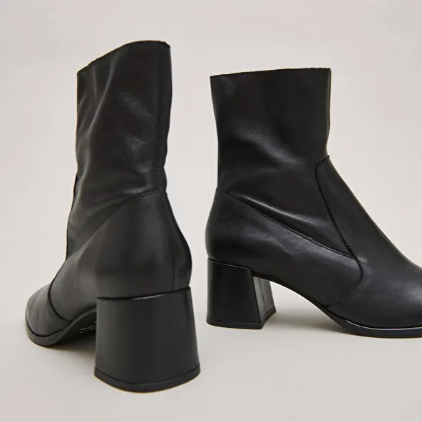 Oval-toe boots in black aged leather